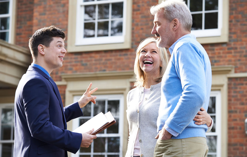 Real estate agents giving keys to the new owner